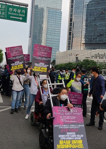 전국장애인차별철페연대가 18일 오전 아모레퍼시픽 본사 앞 횡단보도를 15분간 점거해 “추가경정예산에 장애인권리예산을 반영해달라”고 외친 후, 삼각지역까지 행진하고 있다.ⓒ에이블뉴스